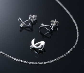 Jewelery set of 8 kt. white gold with diamonds and sterling silver chain. (4)