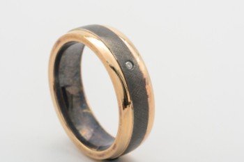 Oxidized sterling silver ring, edges of 14 kt. gold with brilliant of approx. 0.02 ct. Str. 53
